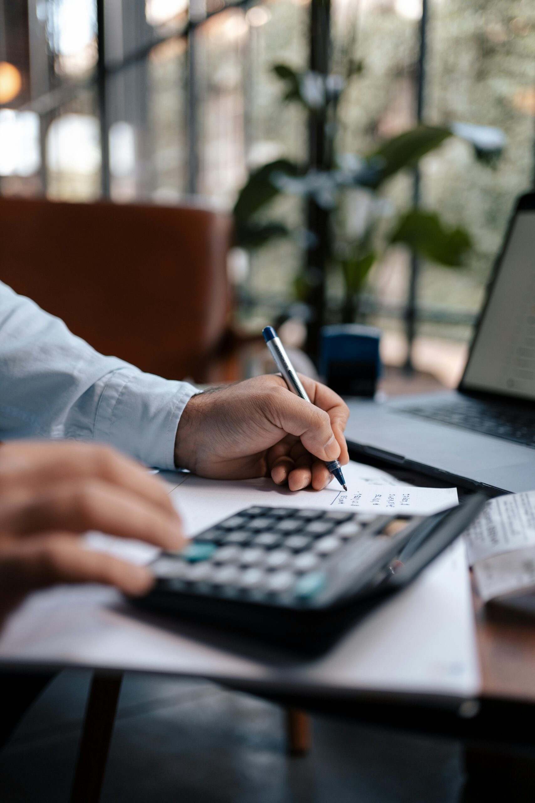 Invest-Smart-Grow-Fast-Your-Small-Business-Guide-to-IT-Expense-Planning-scaled.jpg Free A person calculating finances with a calculator and pen on a desk indoors. Stock Photo